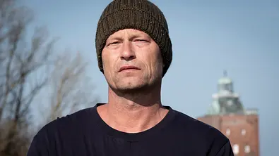 Til Schweiger steht in der Natur und schaut mit schwermütigem Blick in die Ferne. - Foto: WDR/NDR/Christine Schroeder