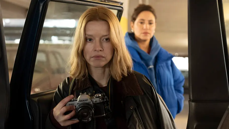 Almila Bagriacik und Karoline Schuch untersuchen beide ein Auto. Schuch hält eine Kamera.