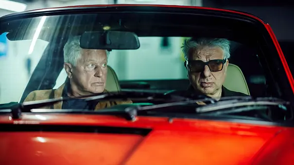 Ivo Batic (Miroslav Nemec) und Franz Leitmayr (Udo Wachtveitl) sitzen in einem roten Porsche. - Foto: BR/NEUESUPER GmbH/Hendrik Heiden Ivo Batic (Miroslav Nemec) und Franz Leitmayr (Udo Wachtveitl) sitzen in einem roten Porsche. - Foto: BR/NEUESUPER GmbH/Hendrik Heiden