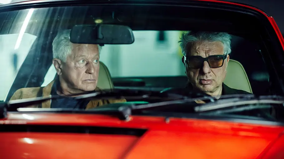 Tatort - Unvergänglich Ivo Batic (Miroslav Nemec) und Franz Leitmayr (Udo Wachtveitl) sitzen in einem roten Porsche.