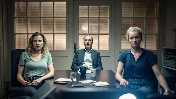 Man sieht das Dresdner Ermittler-Trio Gorniak, Schnabel und Winkler von links nach rechts in einem Konferenzraum. Gorniak trägt ein grünes Oberteil, Schnabel ein Jacket mit blauem Hemd und Winkler eine blaue Bluse.  - Foto: MDR/MadeFor/Marcus Glahn