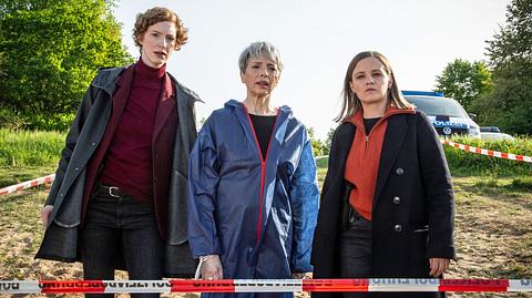 Das Team vom Bremer „Tatort“ steht hinter einer Absperrung. - Foto: Radio Bremen / Claudia Konerding