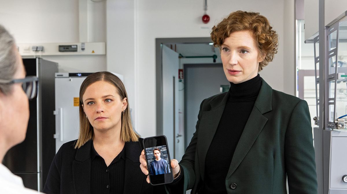 „Tatort: Solange du atmest“ läuft am 11. Mai. Zwei Bremer Ermittlerinnen stehen nebeneinander, eine von ihnen hält ein Handy hoch, darauf ist ein Foto zu sehen.