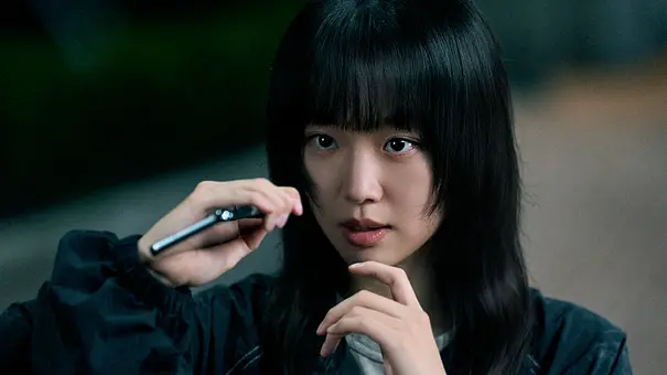 Han-Rim legt ihren Finger ans Kinn und schaut gebannt nach vorne. - Foto: Kim Ji-yeon/Netflix Han-Rim legt ihren Finger ans Kinn und schaut gebannt nach vorne. - Foto: Kim Ji-yeon/Netflix