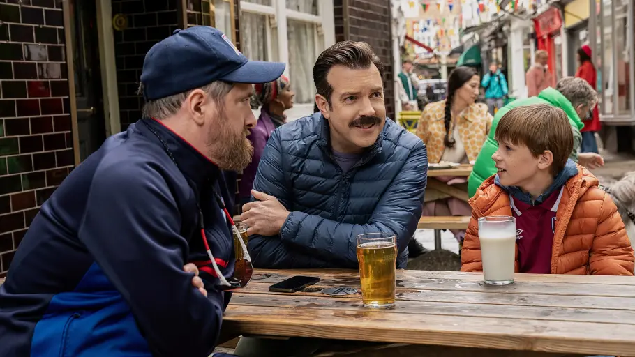 Coach Beard, Ted und Henry sitzen vor dem Pub in Richmond und reden.