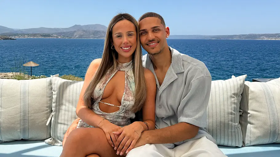 Charleen und Etienne bei Temptation Island Charleen und Etienne sitzen eng nebeneinander auf einer Outdoor-Couch vor einem Meerpanorama und lächelt in die Kamera.