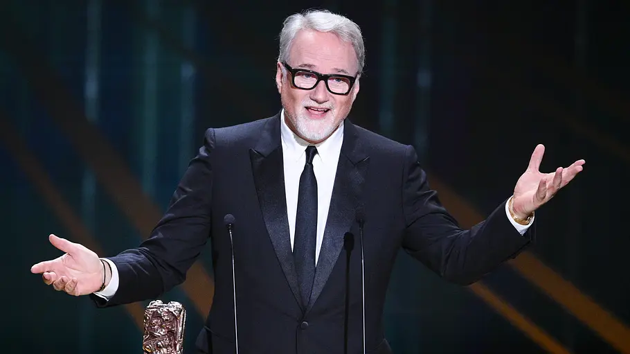 David Fincher steht im Anzug an einem Rednerpult.