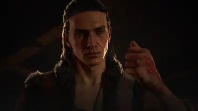 Coen schaut zur Seite, während der seine blutende Hand zusammendrückt. - Foto: Bandai Namco / 