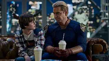 Homelander und sein Junge sitzen mit einem Milkshake auf der Couch und schauen sich in The Boys - Staffel 5 an - Foto: Prime Video