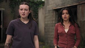 Ellie und Dina blicken schockiert nach vorne. - Foto: HBO