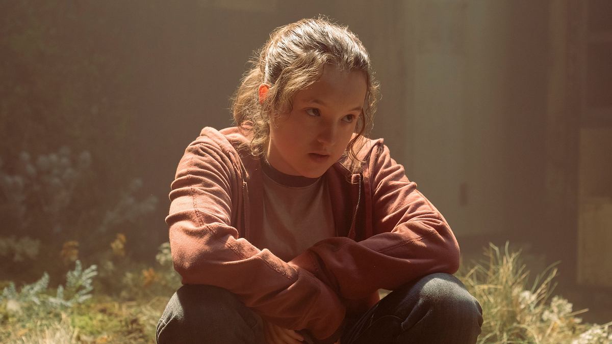 Ersatz für Bella Ramsey in „The Last of Us“ Bella Ramsey sitzt in einer Szene aus „The Last of Us“ als „Ellie“ auf moosigem Boden