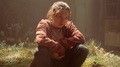 Bella Ramsey sitzt in einer Szene aus „The Last of Us“ als „Ellie“ auf moosigem Boden - Foto: Home Box Office