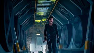 Charlize Theron geht in taktischer Kleidung einen halbrunden Gang entlang, der relativ dunkel anmutet.  - Foto: Netflix