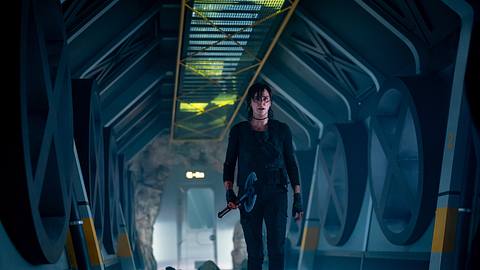 Charlize Theron geht in taktischer Kleidung einen halbrunden Gang entlang, der relativ dunkel anmutet.  - Foto: Netflix