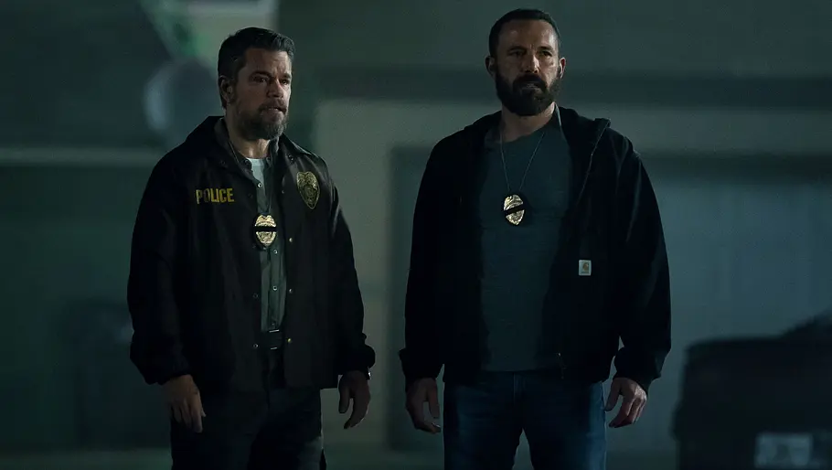 Matt Damon (l.) und Ben Affleck stehen in Cop-Montur nebeneinander.