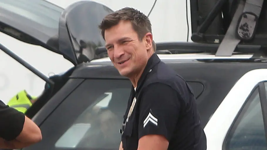 Nathan Fillion als John Nolan Nathan Fillion in seiner Polizei-Uniform als John Nolan. Er lächelt am Set.