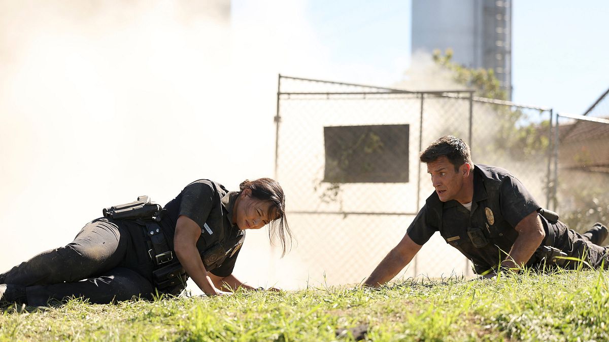 The Rookie „The Rookie“: Lucy und Nolan mit Ruß bedecket auf einer Wiese