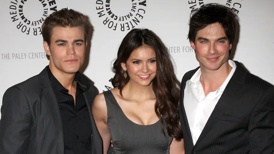 Paul Wesley, Nina Dobrev und Ian Somerhalder auf dem Red Carpet für „The Vampire Diaries“. Die drei lächeln in die Kamera.