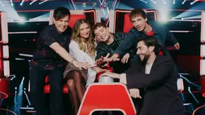 Die Coaches von „The Voice Kids“ sitzen gemeinsam auf den roten Stühlen im Studio und legen ihre Hände übereinander - Foto: Joyn/Christoph Köstlin Die Coaches von „The Voice Kids“ sitzen gemeinsam auf den roten Stühlen im Studio und legen ihre Hände übereinander - Foto: Joyn/Christoph Köstlin