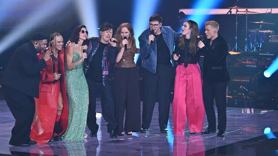 The Voice of Germany Kandidaten Alle Kandidaten singen zusammen mit Michael Patrick Kelly. Sie stehen Arm in Arm auf der Bühne.