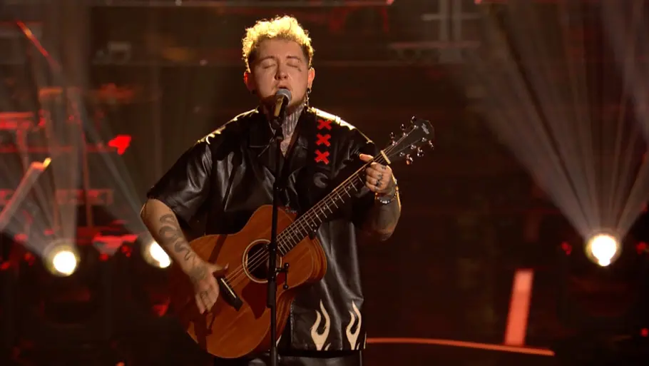 Louk Jones The Voice of Germany Louk Jones steht in den Teamfights von The Voice auf der Bühne mit Gitarre in der Hand und singt mit verschlossenen Augen