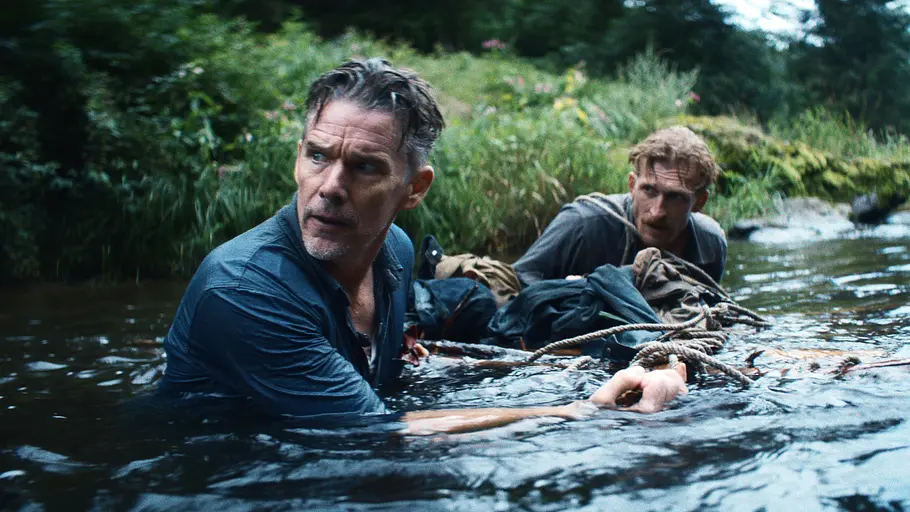 Ethan Hawke und sein Co-Star bewegen sich durch einen Fluss und schauen skeptisch in die Ferne