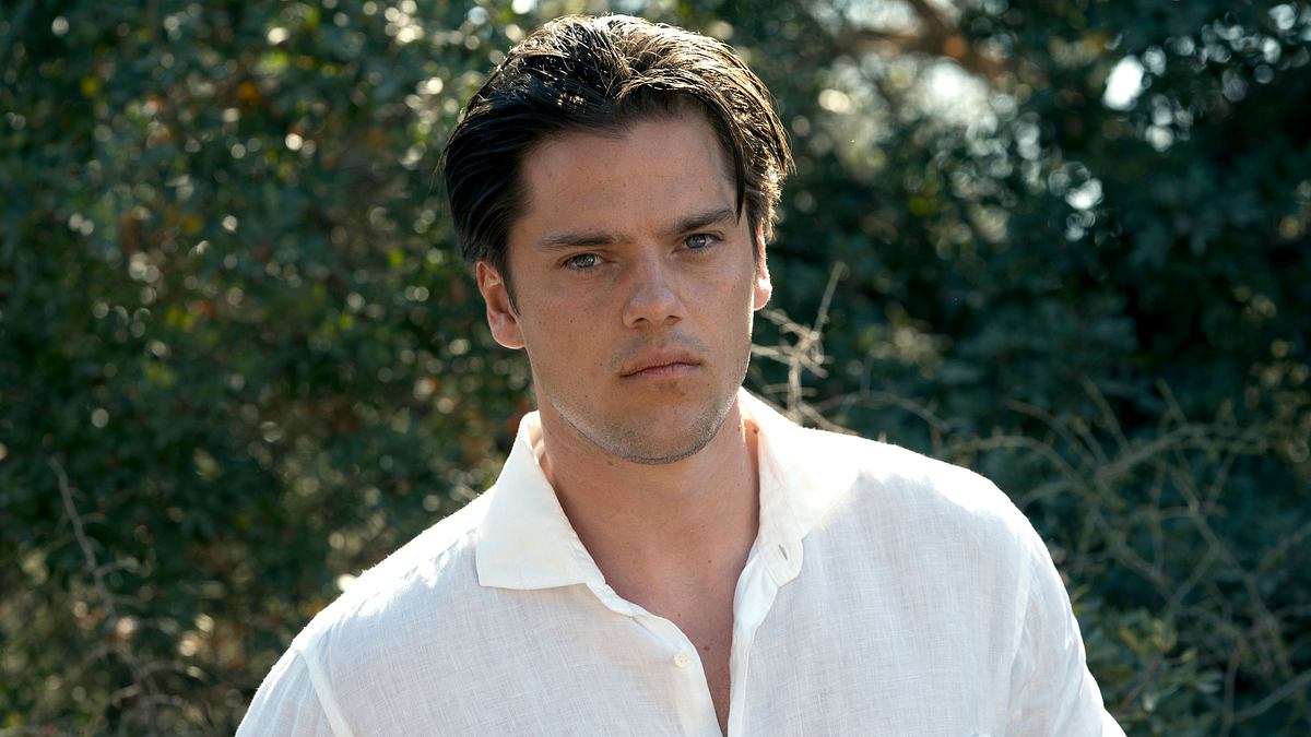 Theo Trebs Netflix Theo Trebs in Netflix „Fall for Me“. ER schaut gerade in die Kamera und trägt ein weißes Hemd.