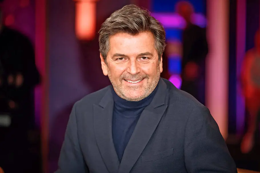 Sänger Thomas Anders lächelt im Studio direkt in die Kamera