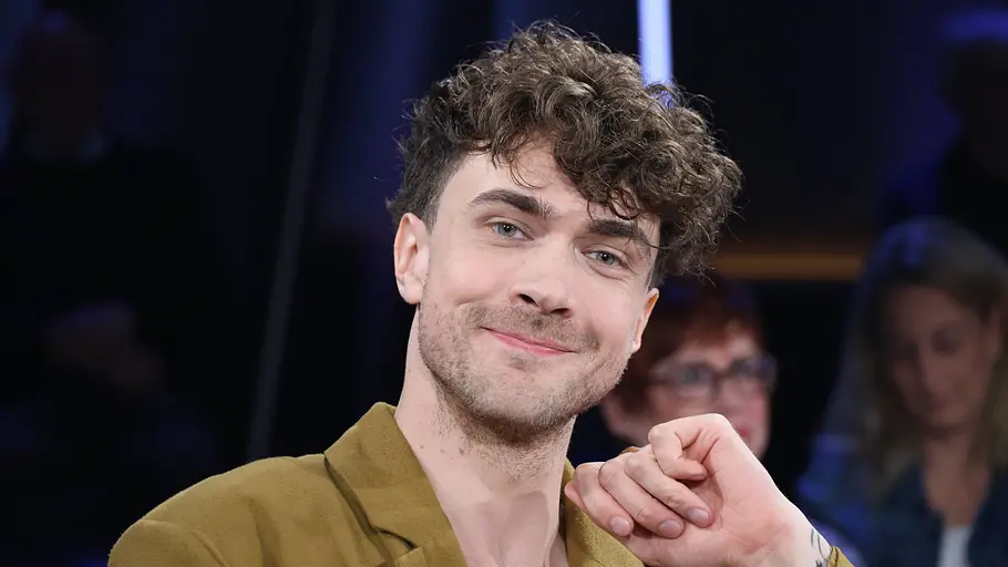 Mentalist Timon Krause im TV-Studio Mentalist Timon Krause sitzt lächelnd in einem TV-Studio und blickt in die Kamera.