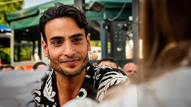 Timur Ülker schaut jemanden an und lächelt leicht. - Foto: IMAGO / Hartenfelser Timur Ülker schaut jemanden an und lächelt leicht. - Foto: IMAGO / Hartenfelser