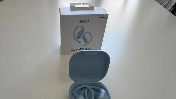 Shokz OpenFit Air 2 im Ladecase vor Produktverpackung auf einem weißen Tisch. - Foto: Privat / Jay Becker Shokz OpenFit Air 2 im Ladecase vor Produktverpackung auf einem weißen Tisch. - Foto: Privat / Jay Becker