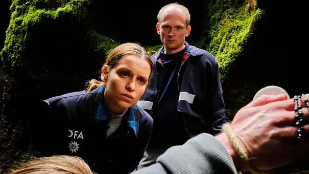 Zwei OFA-Ermittler untersuchen in „Tod am Rennsteig: Auge um Auge“ einen gefesselten Mann an einem düsteren Tatort. - Foto: © MDR/ARD Degeto/Gordon Muehl Zwei OFA-Ermittler untersuchen in „Tod am Rennsteig: Auge um Auge“ einen gefesselten Mann an einem düsteren Tatort. - Foto: © MDR/ARD Degeto/Gordon Muehl