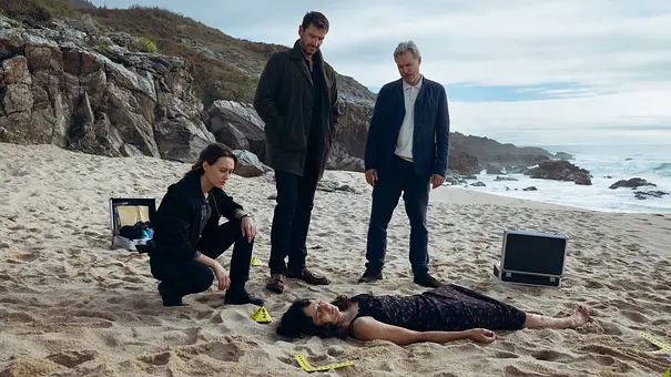 Mercédes Navarro (Mercedes Müller, li.), David Acosta (Michael Epp) und Adrían Martinéz (Dirk Borchardt, re.) schauen sich die tote Sofía Serrano (Sylvana Seddig, unten) genauer an. - Foto: ARD Degeto Film/La Diapo Fotografía Mercédes Navarro (Mercedes Müller, li.), David Acosta (Michael Epp) und Adrían Martinéz (Dirk Borchardt, re.) schauen sich die tote Sofía Serrano (Sylvana Seddig, unten) genauer an. - Foto: ARD Degeto Film/La Diapo Fotografía