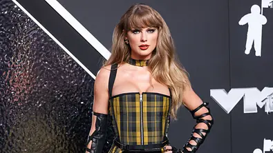 Taylor Swift steht in einem gelb-schwarz karierten Kleid auf dem Red Carpet der Vmas  - Foto: IMAGO / Image Press Agency