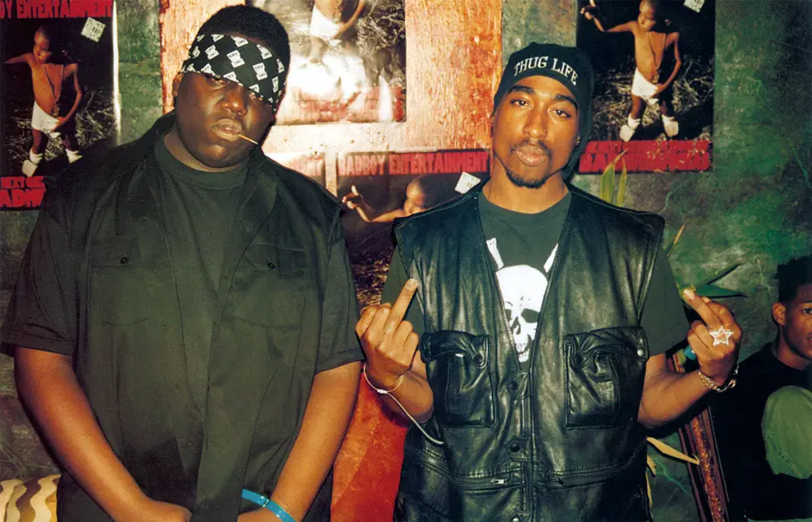 Biggie und Tupac waren mal Freunde. Biggie und Tupac stehen nebeneinander, beide tragen schwarz.