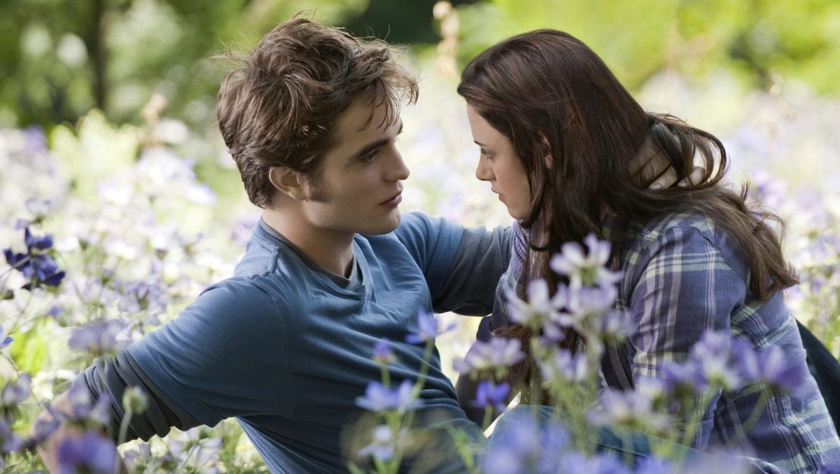 Twilight gratis streamen Bella und Edward sitzen in einem Feld und schauen sich tief in die Augen