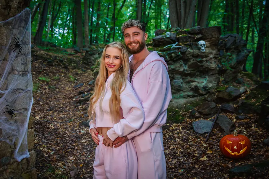 Umut Tekin & Lena Marie Goldstein Umut Tekin & Lena Marie Goldstein steht im Wald zwischen Steinmauern mit Spinnweben, Spinnen, Totenköpfen und einem Kürbis.