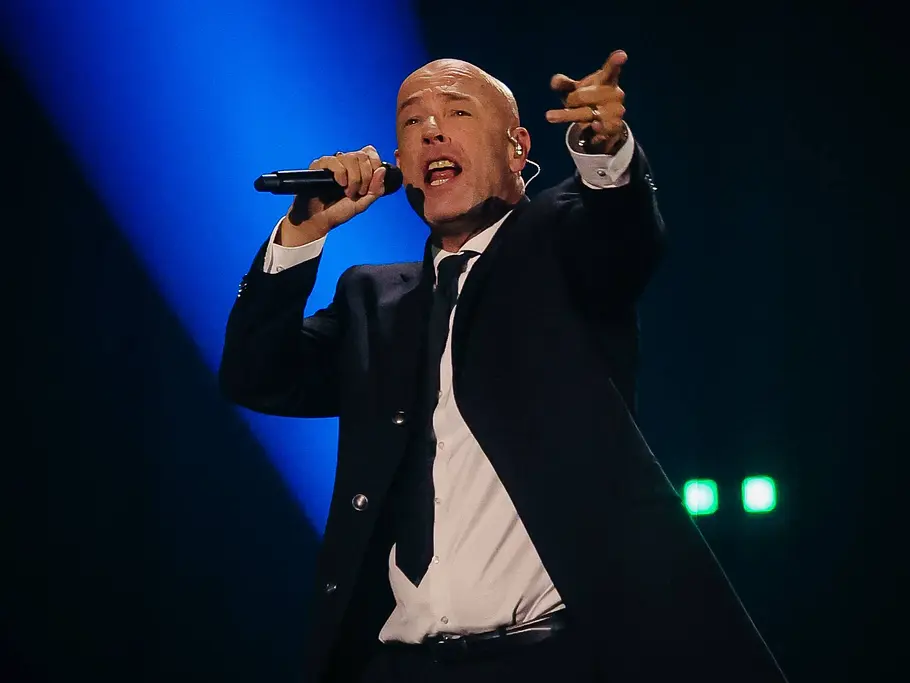 Unheilig bei der „Helene Fischer Show“ 2026 Der Graf von Unheilig singt im schwarzen Anzug ins Mikrofon und streckt eine Hand aus. Blaues Licht erhellt die Bühne.
