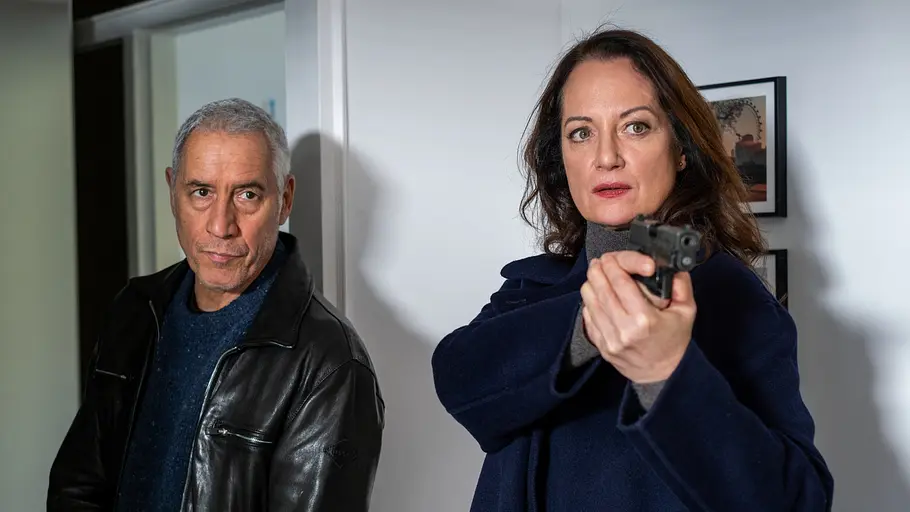 Unter anderen Umständen Matthias Hamm (Ralph Herforth) und Jana Winter (Natalia Wörner) sind in einem Haus. Jana Winter hat ihre Waffe gezogen.