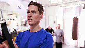 Ringo hält im blauen Sportshirt Trainingsgurte. Im hellen Fitnessraum stehen weitere Personen, rechts hängt ein Boxsack. - Foto: RTL / Sebastian Meyer Ringo hält im blauen Sportshirt Trainingsgurte. Im hellen Fitnessraum stehen weitere Personen, rechts hängt ein Boxsack. - Foto: RTL / Sebastian Meyer