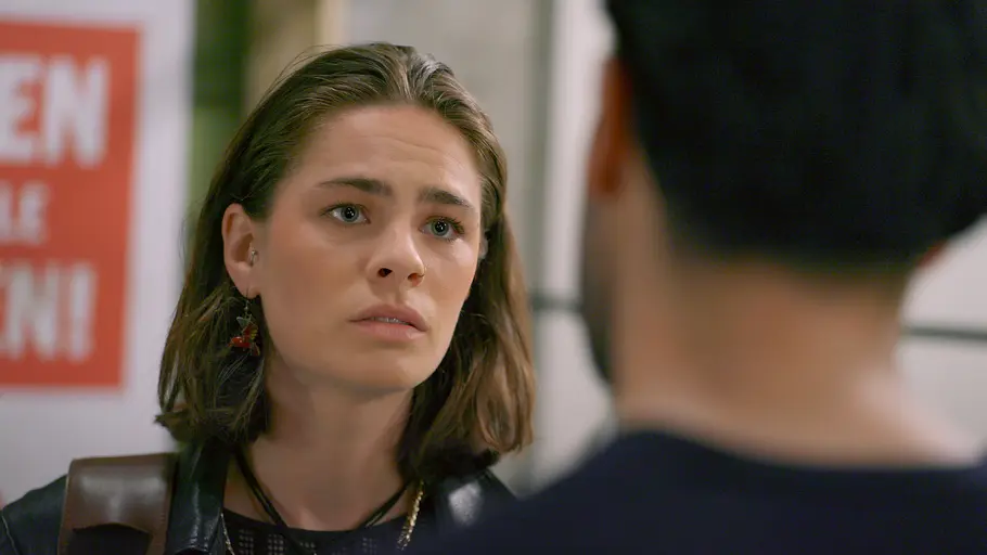 Larissa (Ilka Mahrholz) blickt Baris (Metehan Demiröz) erschrocken an. Er ist unscharf von hinten im Vordergrund zu sehen.