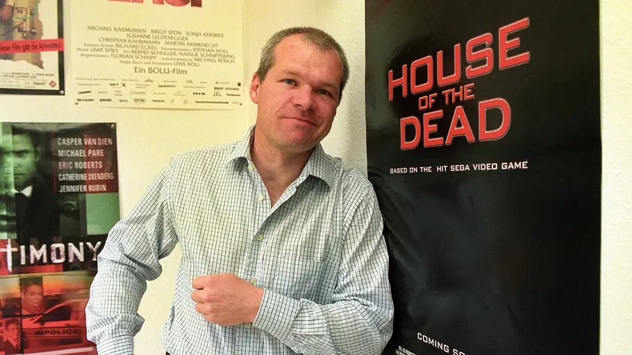 Uwe Boll Uwe Boll posiert lächelnd neben einem Plakat seines Films „House of the Dead“.