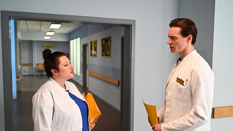 Vanessa und Johannes im Kittel im ernsten Gespräch im Krankenhaus. - Foto: RTL / Julia Feldhagen