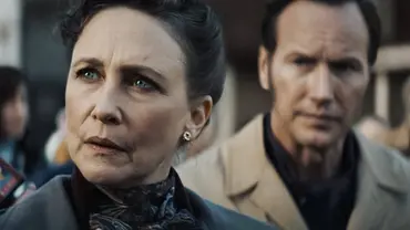 Auf dem Bild sind Vera Farmiga und Patrick Wilson in ihren Rollen als Lorraine und Ed Warren zu sehen. Lorraine blickt ernst und konzentriert nach vorn, während Ed leicht unscharf im Hintergrund steht und sie besorgt beobachtet. Beide wirken angespannt, die Szene vermittelt Dramatik und Ernsthaftigkeit - Foto: IMAGO / Landmark Media Auf dem Bild sind Vera Farmiga und Patrick Wilson in ihren Rollen als Lorraine und Ed Warren zu sehen. Lorraine blickt ernst und konzentriert nach vorn, während Ed leicht unscharf im Hintergrund steht und sie besorgt beobachtet. Beide wirken angespannt, die Szene vermittelt Dramatik und Ernsthaftigkeit - Foto: IMAGO / Landmark Media