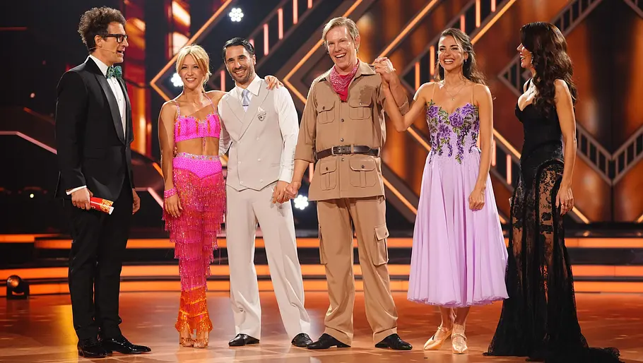 Eine Gruppe von Tänzern, darunter Simon Gosejohann und Ekat, in schillernden Kostümen auf der Let's Dance-Bühne. 