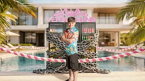 Paddy Kroetz steht mit verschränkten Armen vor einem mit schweren Ketten gesicherten Kühlschrank in der „Villa der Versuchung“. Der Reality-TV-Teilnehmer trägt ein buntes Kurzarmhemd, schwarze Shorts und Badelatschen. Im Hintergrund sind ein Pool, Palmen und das leuchtende Logo der Show zu sehen. - Foto: Joyn Paddy Kroetz steht mit verschränkten Armen vor einem mit schweren Ketten gesicherten Kühlschrank in der „Villa der Versuchung“. Der Reality-TV-Teilnehmer trägt ein buntes Kurzarmhemd, schwarze Shorts und Badelatschen. Im Hintergrund sind ein Pool, Palmen und das leuchtende Logo der Show zu sehen. - Foto: Joyn