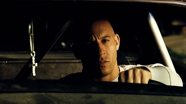 Vin Diesel sitzt bei Fast & Furious hinter dem Steuer und schaut ernst in die Ferne - Foto: IMAGO / FAMOUS