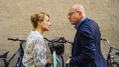 Bloß nicht Liebe: Viola (Christina Große) und Dr. Förster (Heino Ferch) stehen vor einem Fahrradständer, ihre Räder dicht nebeneinander. Sie fixieren sich wütend und entschlossen. - Foto: ZDF/Hendrik Heiden Bloß nicht Liebe: Viola (Christina Große) und Dr. Förster (Heino Ferch) stehen vor einem Fahrradständer, ihre Räder dicht nebeneinander. Sie fixieren sich wütend und entschlossen. - Foto: ZDF/Hendrik Heiden