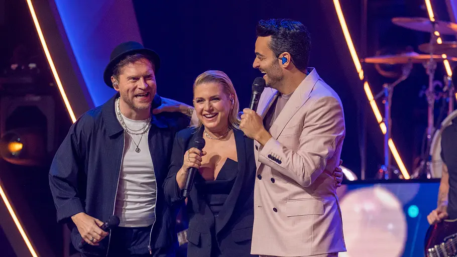 Von links: Johannes Oerding, Jeanette Biedermann, Giovanni Zarrella Die Giovanni Zarrella Show - Ein Abend für die Liebe: Johannes Oerding, Jeanette Biedermann und Giovanni Zarrella stehen gemeinsam auf der Bühne. Sie lachen fröhlich. Im Hintergrund steht der Gitarrist der Giovanni-Zarrella-Band.
