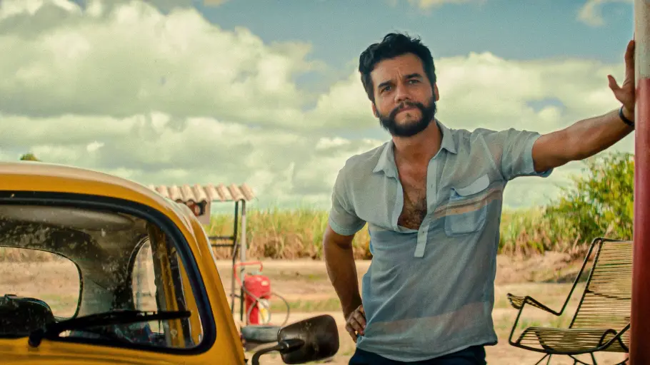 Wagner Moura stützt sich an einer Tanksäule ab.
